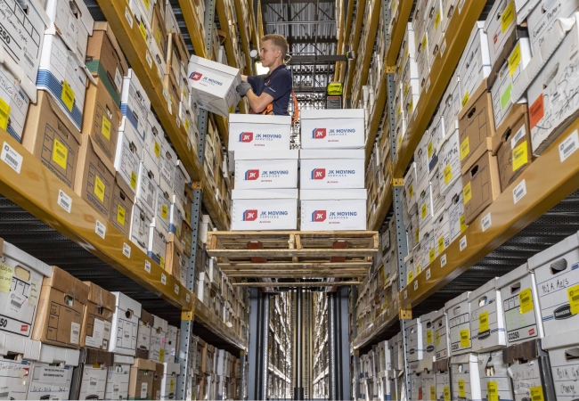 JK Moving storage facility employer placing archives on a shelf