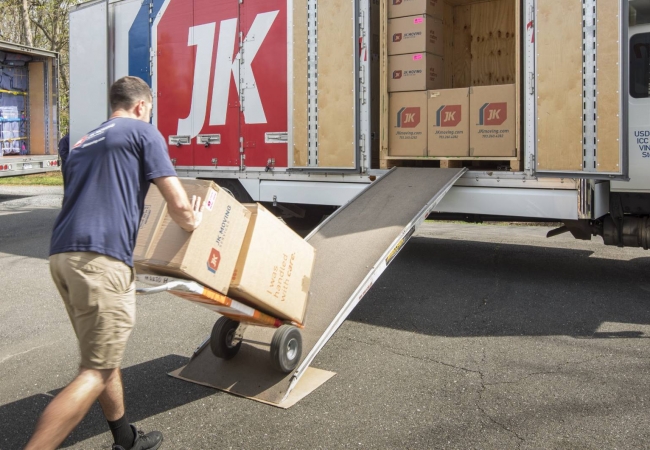 Movers loading a dolly onto a truck