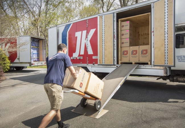 Movers loading a dolly onto a truck