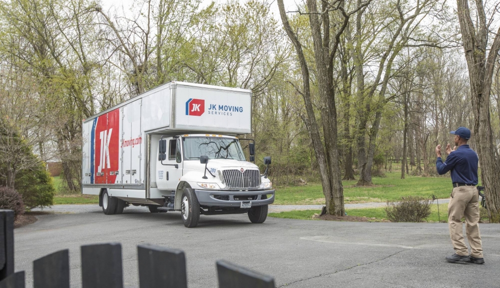 A JK Moving professional directing a truck
