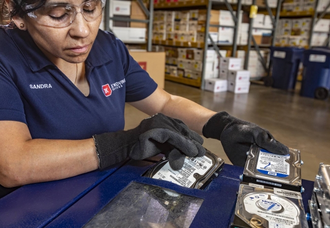 JK Moving employee shredding a hard drive during an office decommissioning project