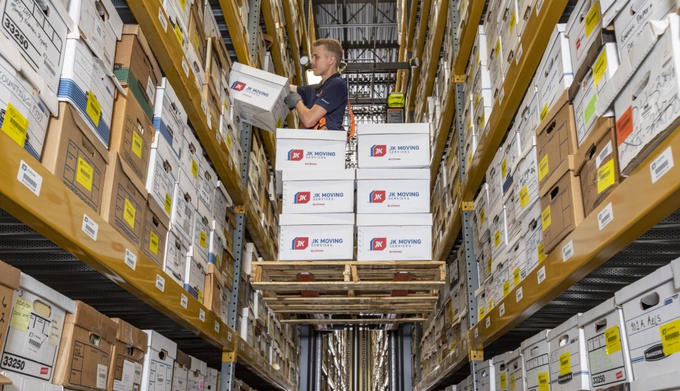 JK Moving storage facility employer placing archives on a shelf