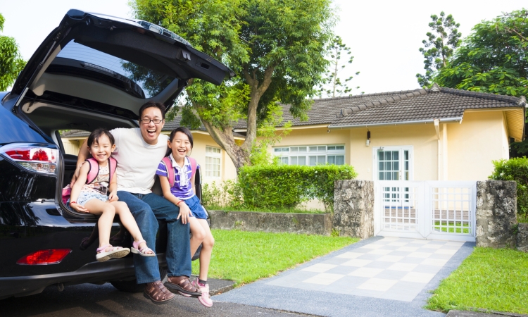 Happy family in front of house