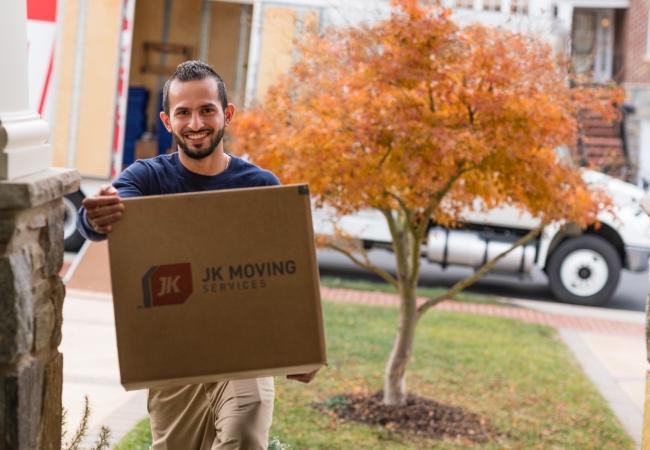 Professional mover with a box, facilitating a residential relocation.
