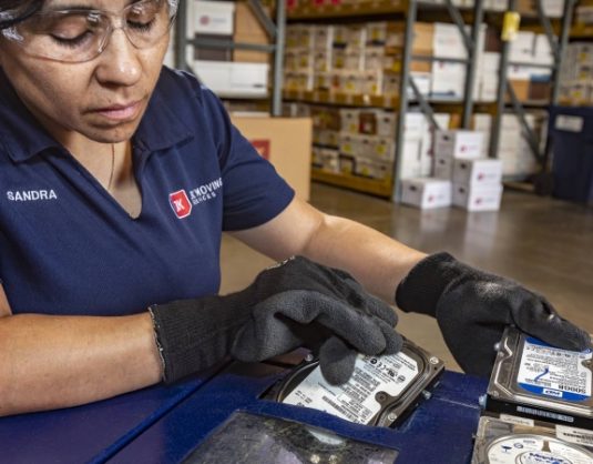 JK Moving employee shredding a hard drive during an office decommissioning project