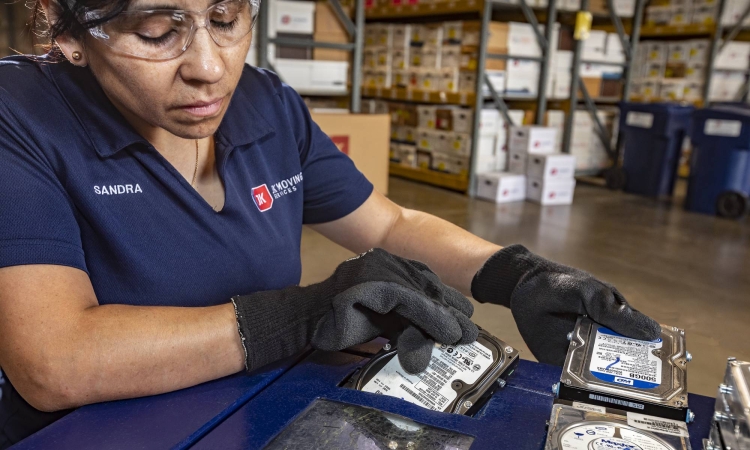 JK Moving employee shredding a hard drive during an office decommissioning project