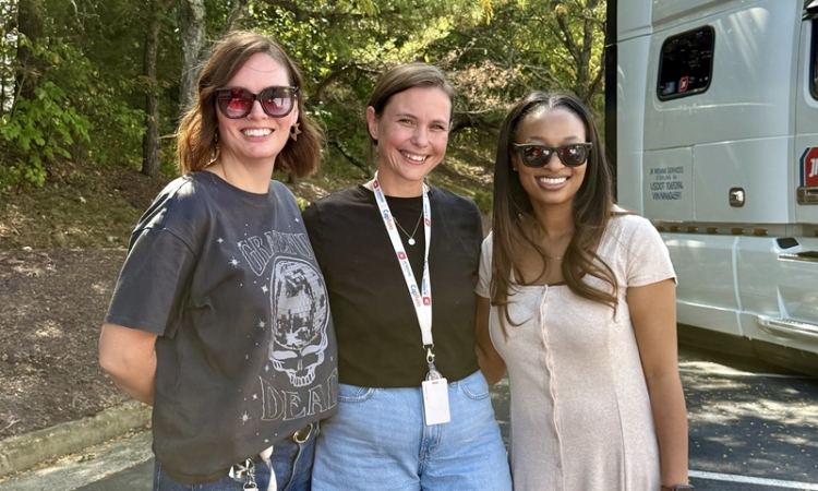Yvonne Koester standing with colleagues outdoors during a JK Moving team event
