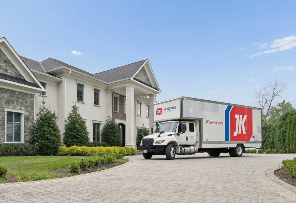 JK Moving truck parked outside a luxury home for a white-glove residential move