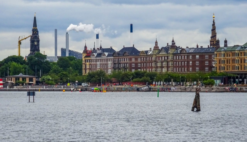 Copenhagen waterfront with historic buildings and church towers across the harbor
